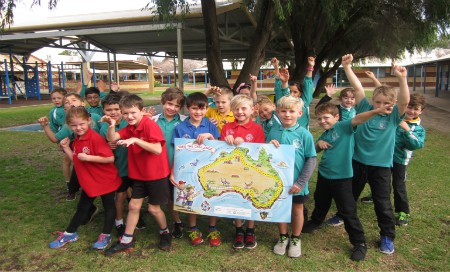 Group of school children hold large map of Australia